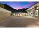 Spacious luxury home with a large motor court, set against a mountain backdrop at twilight at 9820 E Thompson Peak Pkwy # 629, Scottsdale, AZ 85255