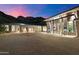 Elegant home showcasing its motor court and grand facade against a desert mountain backdrop at dusk at 9820 E Thompson Peak Pkwy # 629, Scottsdale, AZ 85255