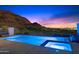 Night view of the pool and spa area, showcasing the illuminated water and desert landscape at 9820 E Thompson Peak Pkwy # 629, Scottsdale, AZ 85255