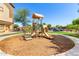 Community playground featuring play structures, surrounded by lush green grass and community buildings at 10136 E Southern Ave # 3065, Mesa, AZ 85209