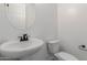 Clean and modern powder room featuring a white pedestal sink and toilet at 11627 W Beck Ave, Youngtown, AZ 85363