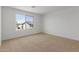 Bright, carpeted bedroom with a large window providing natural light and neighborhood views at 11627 W Beck Ave, Youngtown, AZ 85363