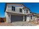 Two-story home with a gray garage door and an inviting brick driveway at 11627 W Beck Ave, Youngtown, AZ 85363
