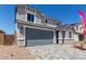 Two-story home showcasing a gray garage door, neutral stucco, decorative trim, and a paver driveway at 11627 W Beck Ave, Youngtown, AZ 85363