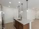 Bright kitchen island illuminated by pendant lights, showcasing stainless steel appliances and sleek white countertops at 11627 W Beck Ave, Youngtown, AZ 85363