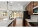 Stylish kitchen showcasing wood cabinets, stainless steel appliances, island, and sliding door access to the backyard at 11627 W Beck Ave, Youngtown, AZ 85363