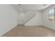 Open-concept living space showcasing tile flooring, a staircase, and natural light from a window at 11627 W Beck Ave, Youngtown, AZ 85363