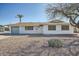 Charming single-story home with a desert landscaped front yard, a palm tree, and a two-car garage at 12021 N Riviera Ct, Sun City, AZ 85351