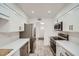 Modern kitchen with stainless steel appliances, white cabinets, stylish hardware, and wood-look tile floors at 12021 N Riviera Ct, Sun City, AZ 85351
