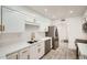 Modern kitchen with stainless steel appliances, white cabinets, stylish hardware, and quartz countertops at 12021 N Riviera Ct, Sun City, AZ 85351
