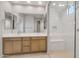 Light filled bathroom featuring double sinks, modern fixtures, an open-concept shower, and a large mirror at 13548 W Copperleaf Ln, Peoria, AZ 85383