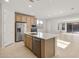 Open-concept kitchen boasts stainless steel appliances, an island with a sink, and plenty of cabinet space at 13548 W Copperleaf Ln, Peoria, AZ 85383