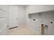 Functional laundry room with tile flooring, built-in shelving, and utility connections for appliances at 13548 W Copperleaf Ln, Peoria, AZ 85383
