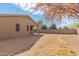 Spacious backyard with gravel and dirt areas, a covered patio, and a block wall fence for privacy at 1380 W Angus Rd, San Tan Valley, AZ 85143