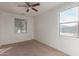 This bedroom boasts carpet flooring, a ceiling fan, and plenty of sunlight from two windows at 1380 W Angus Rd, San Tan Valley, AZ 85143