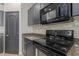 Contemporary kitchen featuring black appliances, stylish cabinetry, and subway tile backsplash at 1380 W Angus Rd, San Tan Valley, AZ 85143