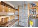 Unfinished storage room with rustic wood shelves and a grey hot water tank at 14644 N Yerba Buena Way # C, Fountain Hills, AZ 85268