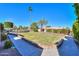 Landscaped backyard lawn with mature palm trees and brick-lined walkways, enhance this home's outdoor appeal at 1520 E Elmwood Cir, Mesa, AZ 85203