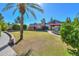 View of landscaped backyard lawn with walkways, mature trees, and the home's exterior at 1520 E Elmwood Cir, Mesa, AZ 85203