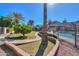 A home backyard featuring a pool, mature landscaping, and a brick-lined walkway at 1520 E Elmwood Cir, Mesa, AZ 85203