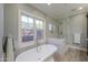 Bright bathroom featuring a freestanding tub under a window and a glass-enclosed shower with marble details at 1520 E Elmwood Cir, Mesa, AZ 85203