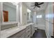 Bright bathroom featuring a double vanity, granite countertops, and a shower-tub combo with tiled walls at 1520 E Elmwood Cir, Mesa, AZ 85203