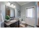 Elegant bathroom with granite vanity, framed mirror, and natural light streaming in from an adjacent exterior door at 1520 E Elmwood Cir, Mesa, AZ 85203