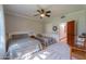 Light bedroom featuring two beds, a ceiling fan, and wainscotting at 1520 E Elmwood Cir, Mesa, AZ 85203