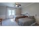Well-lit bedroom with two beds, a ceiling fan, and a large window with light-filtering curtains at 1520 E Elmwood Cir, Mesa, AZ 85203