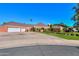 Beautiful brick home showcasing a spacious three-car garage, lush landscaping, and ample parking at 1520 E Elmwood Cir, Mesa, AZ 85203