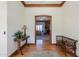 Inviting foyer with wood floors, an accent rug, vintage furniture, and a glimpse into the brick fireplace living room at 1520 E Elmwood Cir, Mesa, AZ 85203
