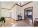 Spacious foyer with wooden accents, light hardwood floors, a vintage area rug, and a view into the living room at 1520 E Elmwood Cir, Mesa, AZ 85203