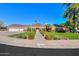 Charming brick home featuring a well-manicured lawn, mature landscaping, and a classic tile roof at 1520 E Elmwood Cir, Mesa, AZ 85203