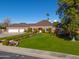 Inviting brick home featuring a well-maintained lawn, manicured hedges, and a spacious garage at 1520 E Elmwood Cir, Mesa, AZ 85203