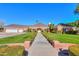 Charming single-story home with a beautiful red brick facade, manicured lawn, and a three-car garage at 1520 E Elmwood Cir, Mesa, AZ 85203