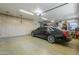 Clean garage with epoxy flooring, cabinets, workspace, and a sleek black car at 1520 E Elmwood Cir, Mesa, AZ 85203