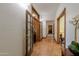 Inviting hallway with hardwood floors and natural wood trim leading to various rooms of the home at 1520 E Elmwood Cir, Mesa, AZ 85203