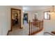 Upstairs hallway showcasing wooden railing and trim, with views into other rooms, creating a warm, inviting atmosphere at 1520 E Elmwood Cir, Mesa, AZ 85203