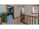 Upstairs hallway with hardwood railing leading to rooms including the laundry room and a decorative stained glass window at 1520 E Elmwood Cir, Mesa, AZ 85203