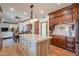 Spacious kitchen featuring a center island, wooden cabinetry, granite countertops, and hardwood floors at 1520 E Elmwood Cir, Mesa, AZ 85203