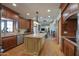 Open concept kitchen with a center island, wooden cabinetry, granite countertops, and hardwood floors at 1520 E Elmwood Cir, Mesa, AZ 85203