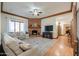 Relaxing living room with a brick fireplace, plush sofa, and ample natural light at 1520 E Elmwood Cir, Mesa, AZ 85203