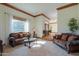 Bright living room featuring carpet floors, a large window, and a view into the foyer and entry way at 1520 E Elmwood Cir, Mesa, AZ 85203
