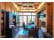 Comfortable office space featuring wood paneling, custom cabinetry, a brick fireplace, and backyard view at 1520 E Elmwood Cir, Mesa, AZ 85203