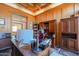 Traditional office with wood paneling, a spacious desk, and built-in bookshelves for storage and display at 1520 E Elmwood Cir, Mesa, AZ 85203