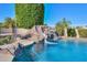 Luxurious pool with rock waterfall feature and lush landscaping at 1520 E Elmwood Cir, Mesa, AZ 85203