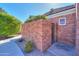 A brick wall, side yard with manicured landscaping, and a charming gate entrance to the home at 1520 E Elmwood Cir, Mesa, AZ 85203