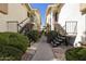 Exterior view of a condo complex with black exterior stairs and mature landscaping with desert rock at 16615 E Gunsight Dr # 205, Fountain Hills, AZ 85268