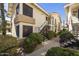 Condo complex with black exterior stairs and railings, lush green landscaping, and a well-maintained sidewalk at 16615 E Gunsight Dr # 205, Fountain Hills, AZ 85268