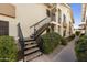 Exterior stairs with black railings leading to the condo entrance surrounded by mature landscaping at 16615 E Gunsight Dr # 205, Fountain Hills, AZ 85268